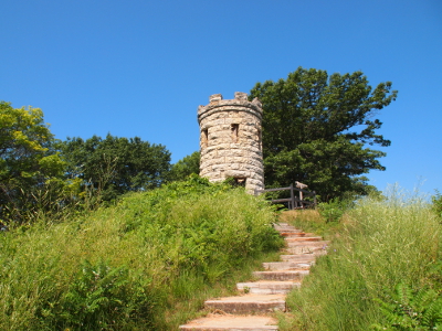 [A series of stone steps lead up to a circular stone tower which resembles a corner turrent of a medieval castle only this stone is light-colored.]